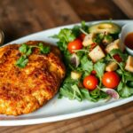 milanesa steak :A plate featuring a crispy golden patty with a fresh salad and dipping sauces.